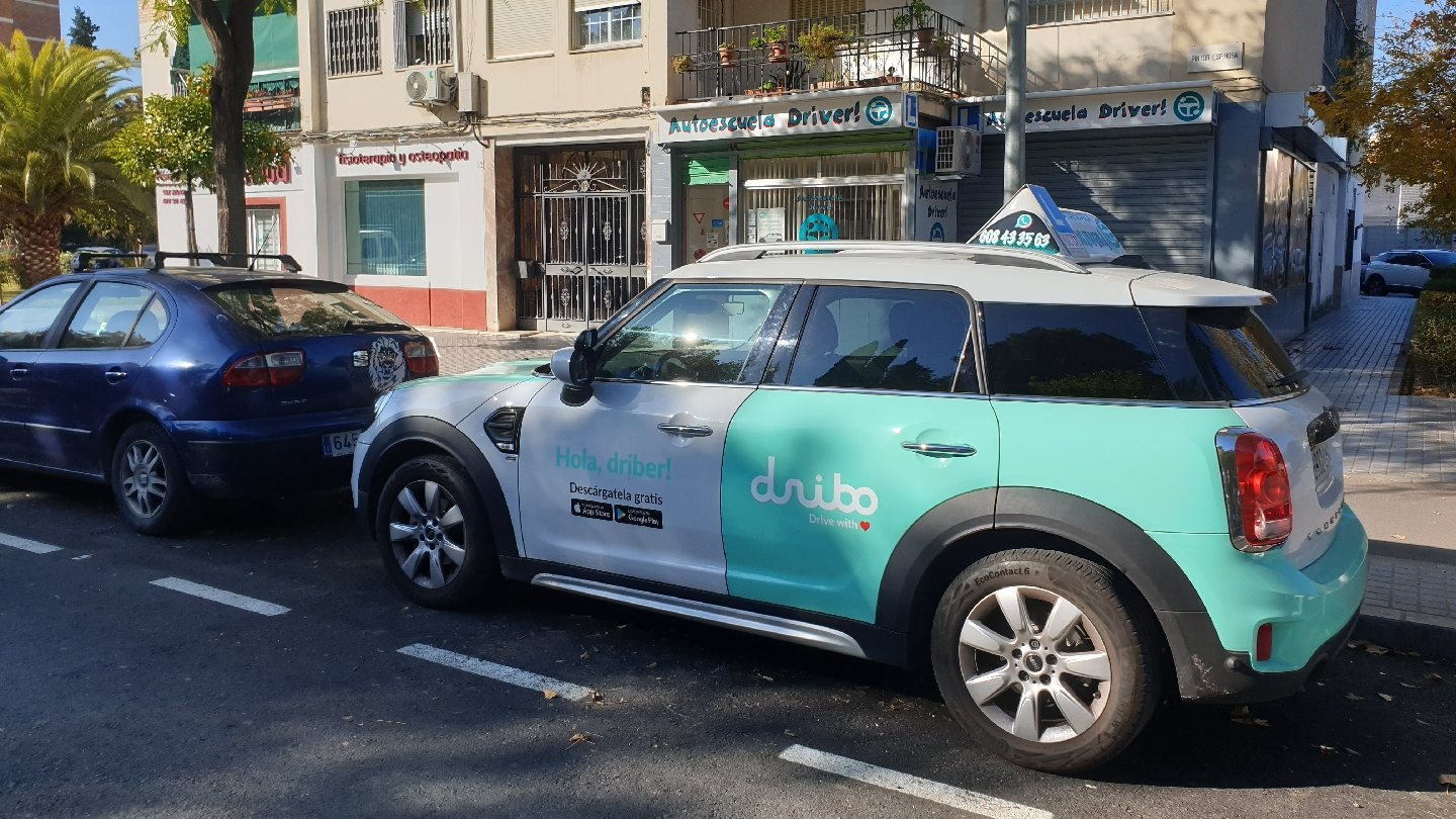 Coche de prácticas de Autoescuela Driver, blanco y verde menta, en la calle Pintor Espinosa